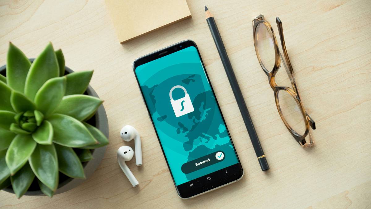 Metal credit card with phone showing active account security alerts