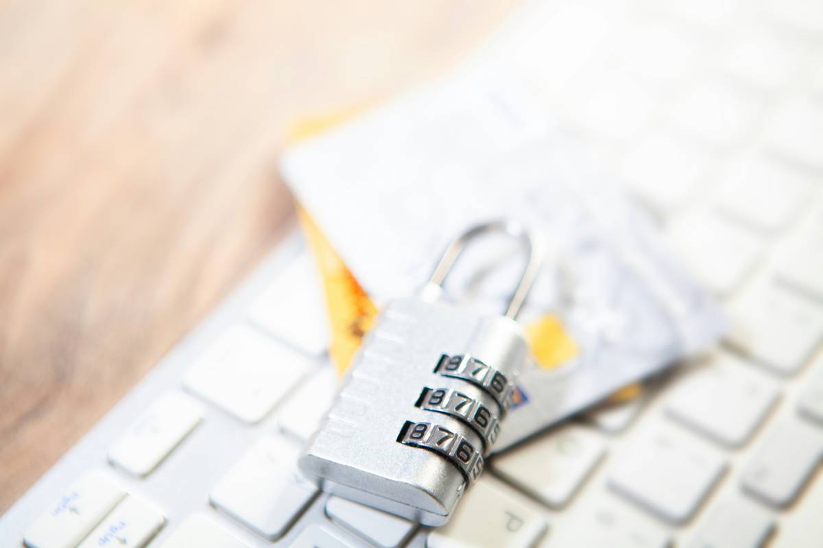 A hand holding a metal credit card next to a smartphone showing active card safety programs alert